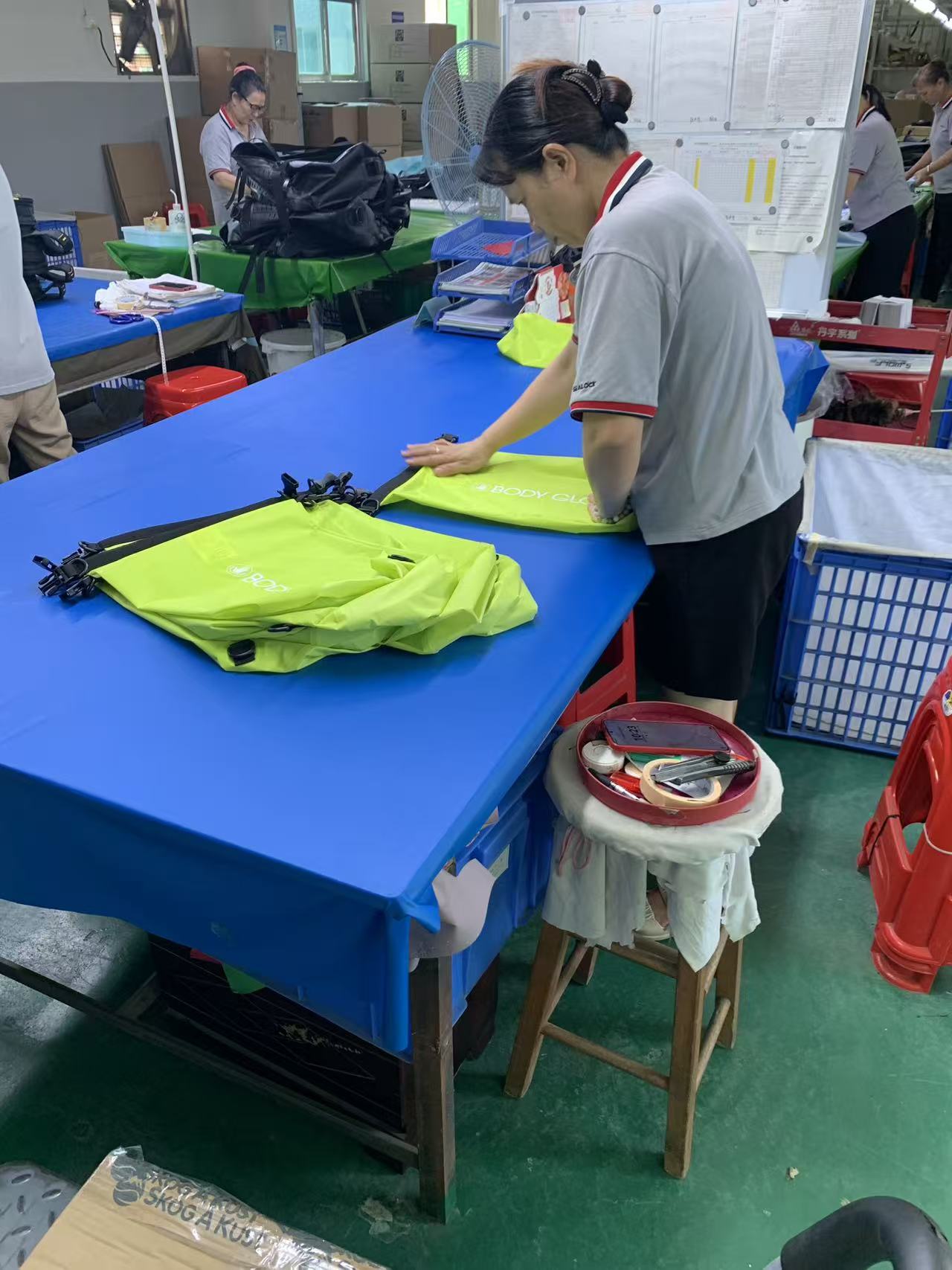 Cómo se cose, verifica y empaqueta un pedido de bolsa seca con tapa enrollable de alta visibilidad